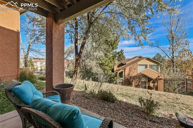 a view of a chair and tables in the back yard of the house