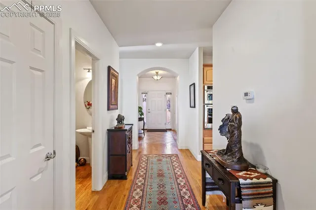 a view of a hallway with wooden floor and furniture