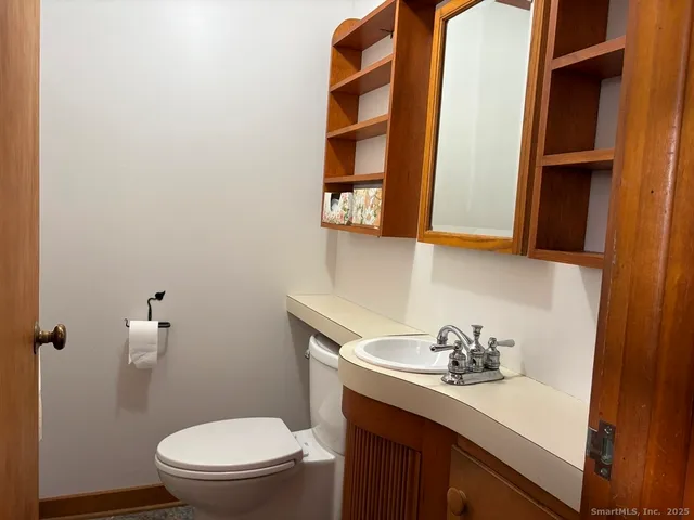 a bathroom with a sink a toilet and a mirror