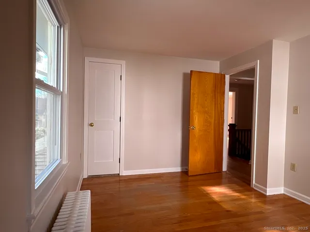 a view of an empty room with closet and a window