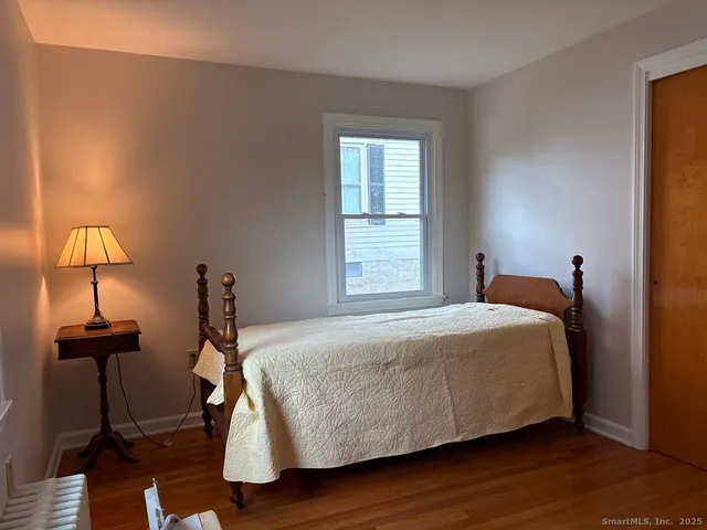 a bedroom with a bed and two windows