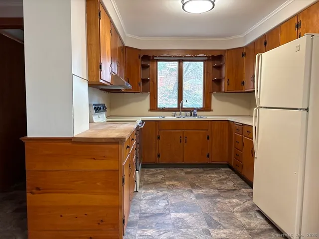 a kitchen with a refrigerator sink and cabinets