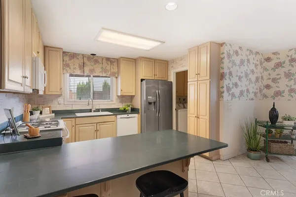 a kitchen with stainless steel appliances granite countertop a refrigerator a stove and white cabinets with wooden floor