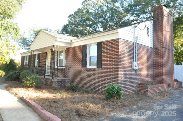a view of a house with a yard and large tree