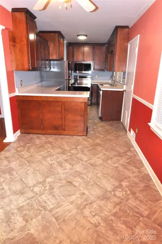a large kitchen with stainless steel appliances granite countertop a sink stove and cabinets
