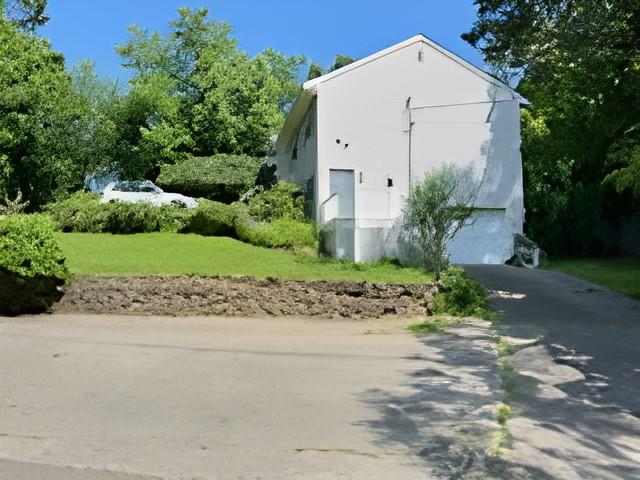 60 Aloma Road Rocky Point, NY 11778 - Photo 22 of 34 a white house with a small yard plants and large trees with wooden fence