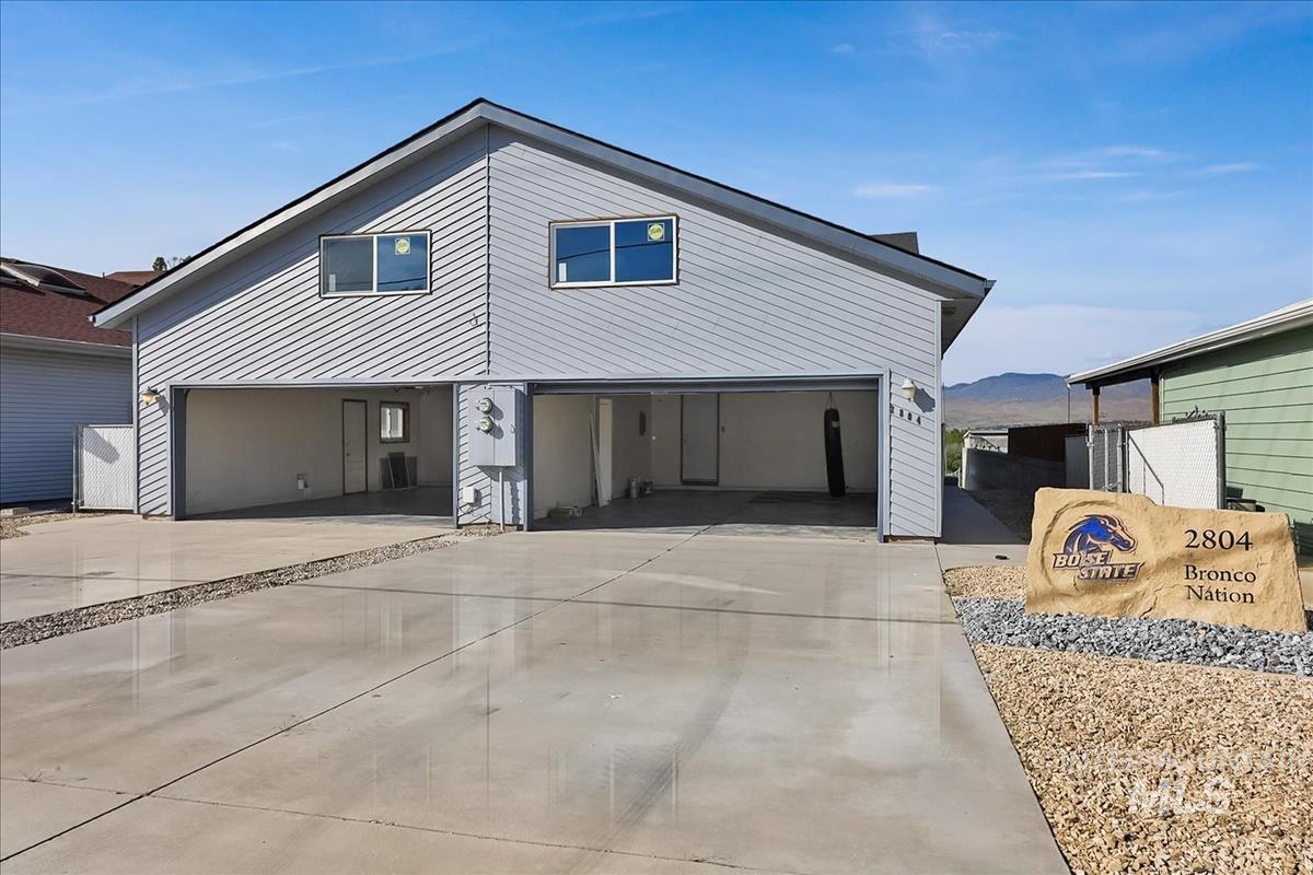 2804 West Sunrise Rim Road Boise, ID 83705 - Photo 3 of 50 Light gray siding exterior with a pitched roof and a two-car garage