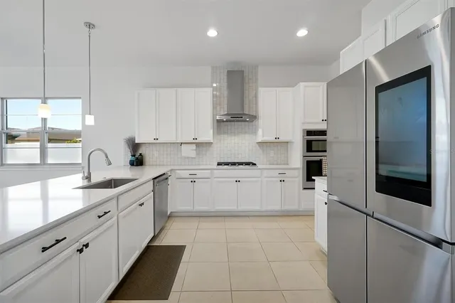 a kitchen with white cabinets and appliances