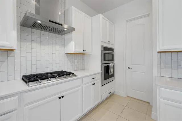 a kitchen with a stove and white cabinets