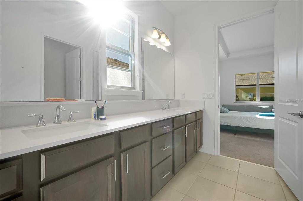 5200 Myrtleleaf Court St. Cloud, FL 34772 - Photo 20 of 59 a en suite bathroom with a double vanity sink and a mirror