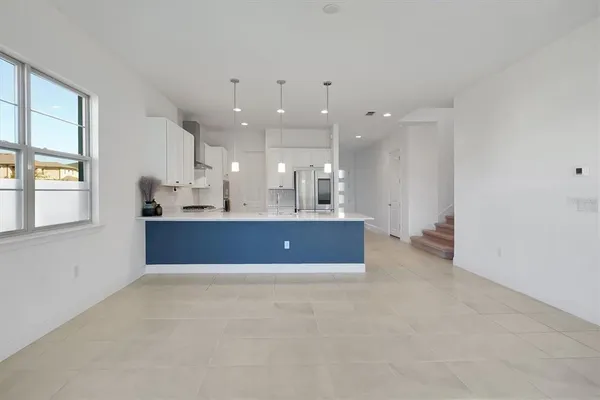 a kitchen with white cabinets and appliances