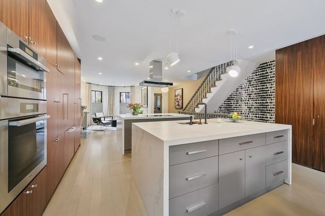a view of a kitchen with kitchen island a sink stainless steel appliances and cabinets