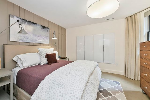 a bedroom with a bed and a painting on the wall