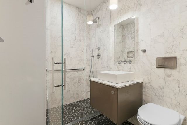 a bathroom with a granite countertop sink toilet and shower