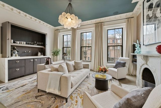 a living room with furniture fireplace and a large window