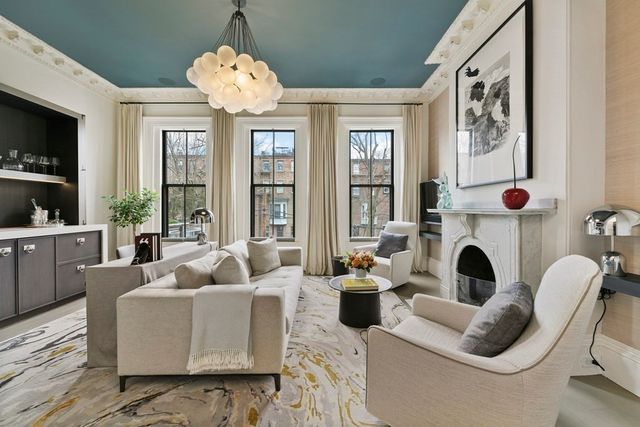 a living room with furniture fireplace and large windows