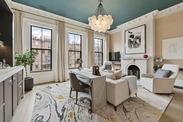 a living room with furniture a fireplace and a chandelier