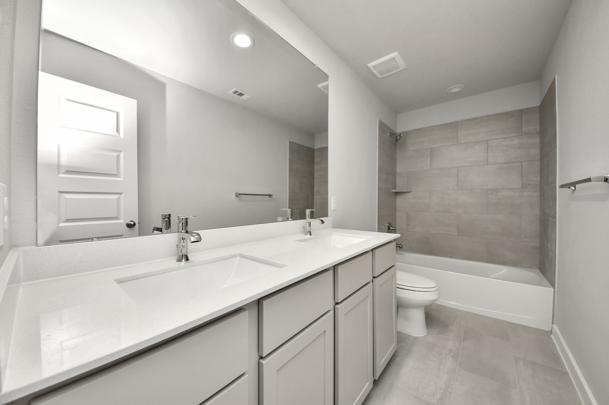 2934 Burris Park Drive Spring, TX 77373 - Photo 29 of 35 Secondary bath features tile flooring, bath/shower combo with tile surround, light stained wood cabinets, beautiful light countertop. Sample photo of completed home with similar floor plan. Actual colors and selections may vary.