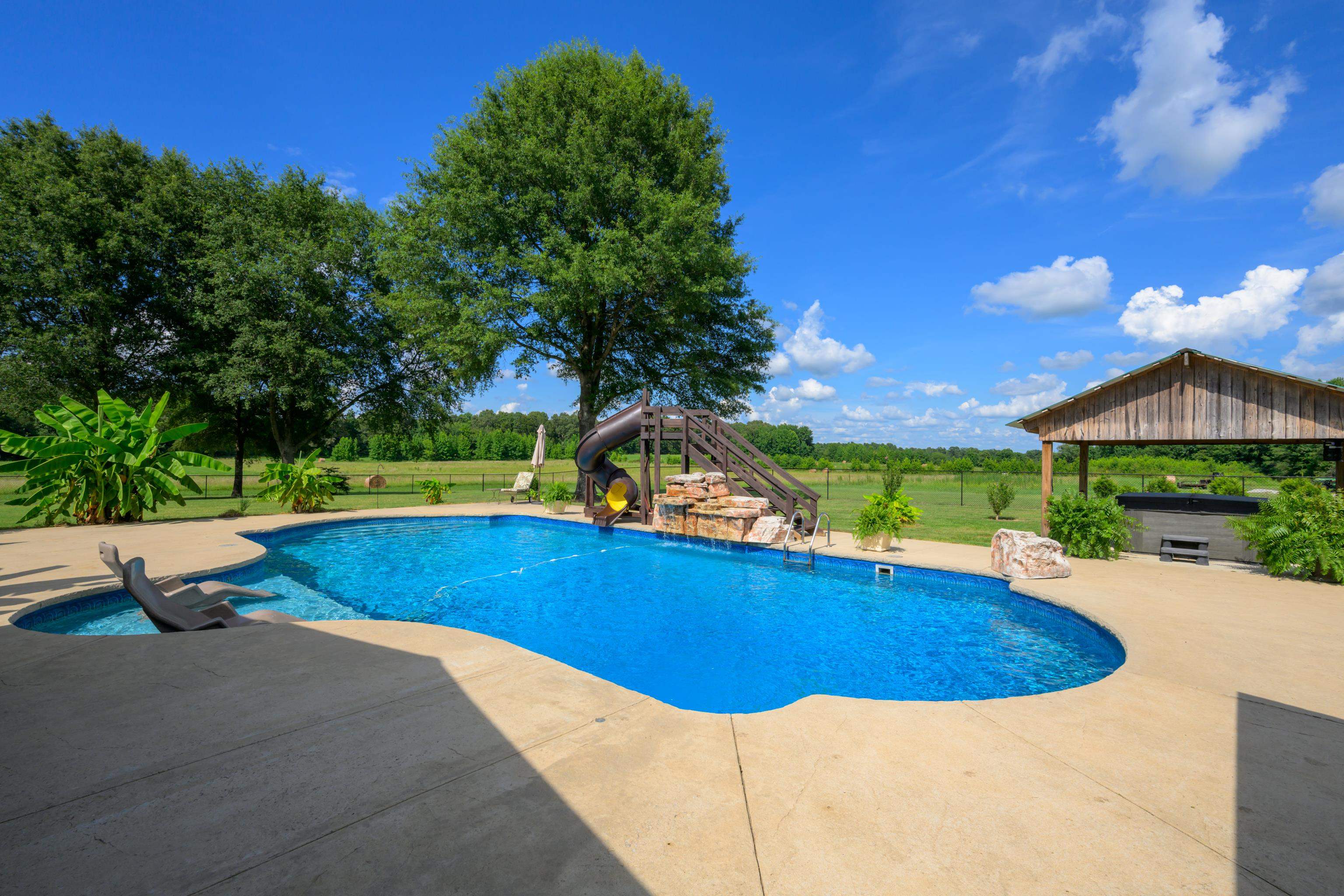 1354 Wilburn Road Michigan City, MS 38647 - Photo 25 of 40 a view of a swimming pool with lawn chairs under an umbrella