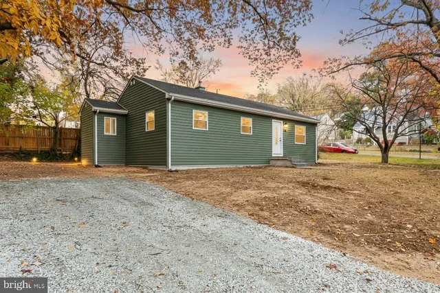 a backyard of a house with large trees and a yard