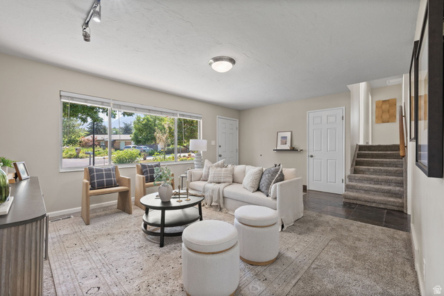 2370 Quail Run Circle East Sandy, UT 84093 - Photo 5 of 54 Living area featuring large windows, track lighting, and a neutral color palette