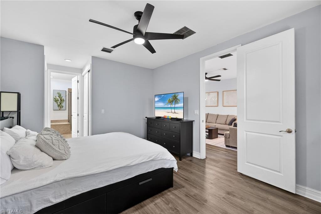 7845 Bristol Circle Naples, FL 34120 - Photo 16 of 31 a bedroom with a bed and wooden floor