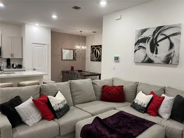 a living room with furniture and glass door