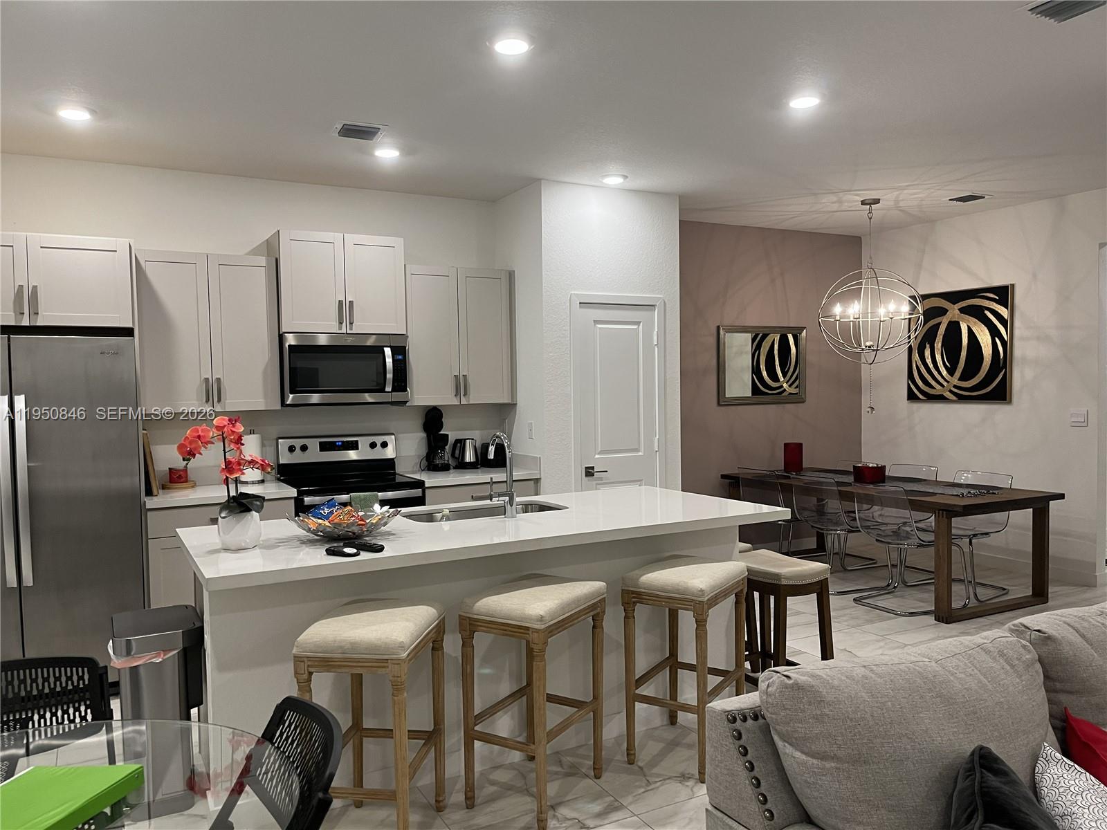784 Southeast 19th Street, Unit 784 Homestead, FL 33034 - Photo 11 of 22 a kitchen that has a table chairs refrigerator and cabinets