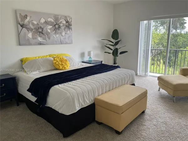 a bedroom with a bed a couch and a window