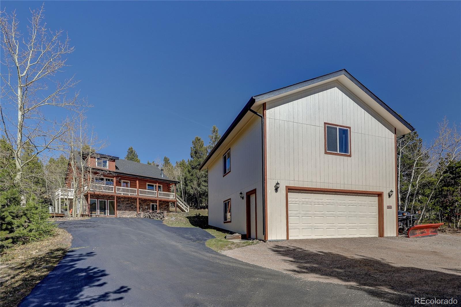 11142 Conifer Mountain Road Conifer, CO 80433 - Photo 2 of 50 a front view of a house with a yard and garage
