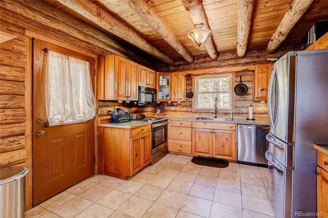 a kitchen with a sink window and stainless steel appliances