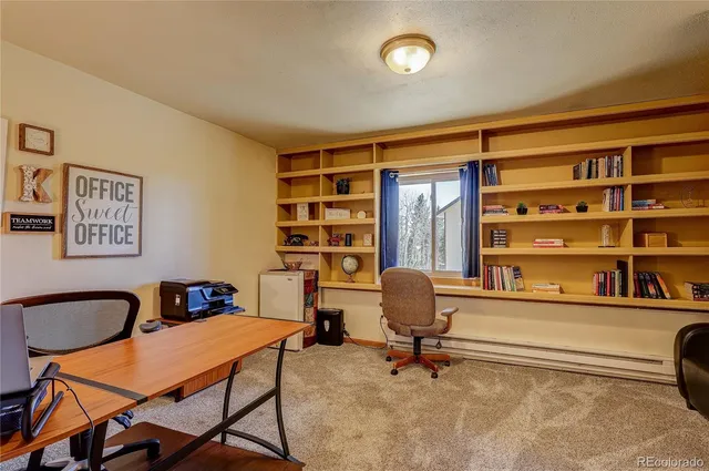 a view of a workspace with furniture and a window