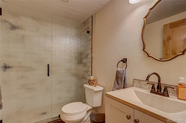 a bathroom with a sink toilet and a mirror