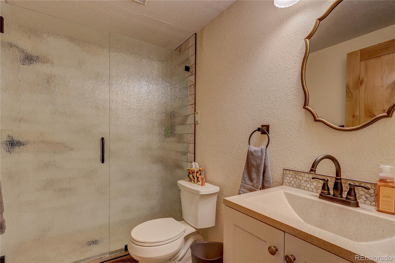 11142 Conifer Mountain Road Conifer, CO 80433 - Photo 34 of 50 a bathroom with a sink toilet and a mirror
