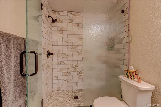 a white toilet sitting next to a shower