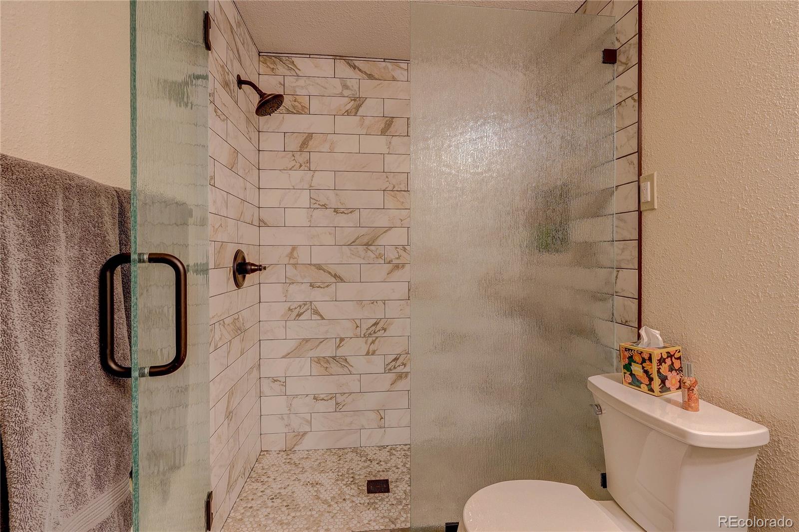 11142 Conifer Mountain Road Conifer, CO 80433 - Photo 35 of 50 a white toilet sitting next to a shower