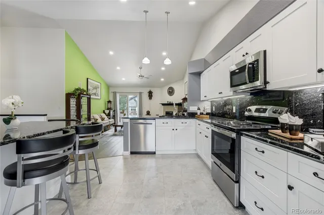 a kitchen with stainless steel appliances kitchen island granite countertop a sink and cabinets