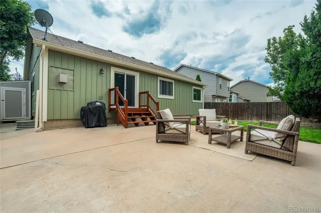 a view of a patio with couches and a table and chairs under an umbrella