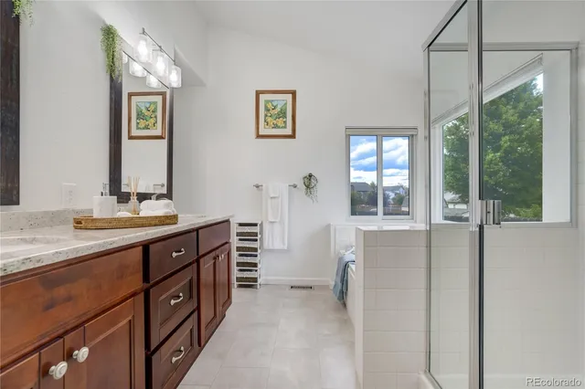 a spacious bathroom with a double vanity sink a mirror and a shower