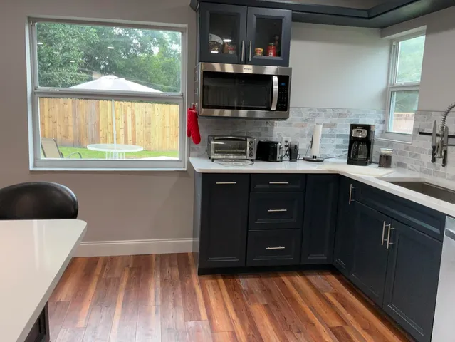 a kitchen with kitchen island a sink appliances and a counter top space