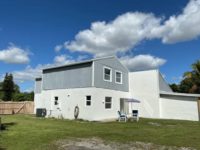 a view of backyard with green space and trees