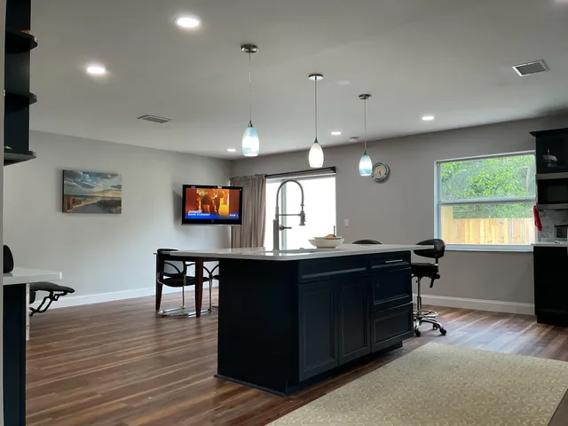 a kitchen with a refrigerator a stove top oven a sink cabinets and wooden floor