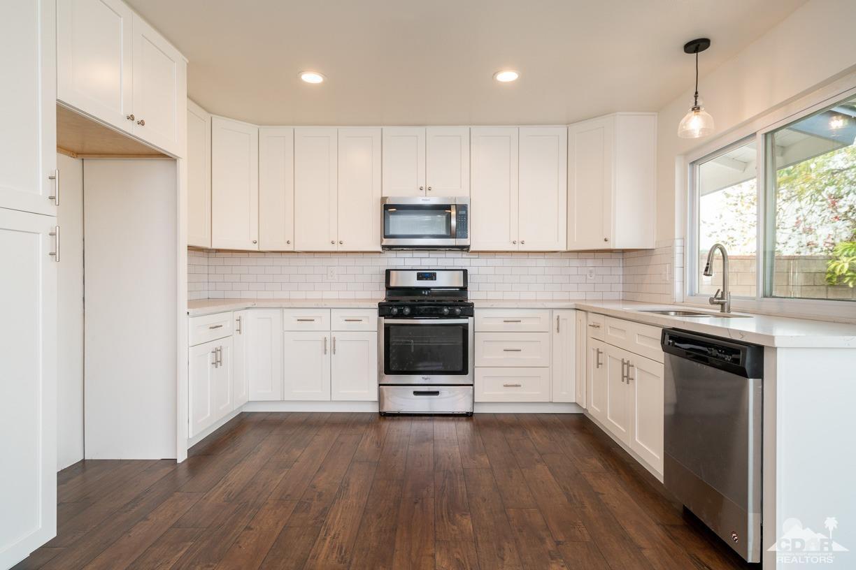 6987 Manhattan Drive Riverside, CA 92506 - Photo 2 of 28 a kitchen with granite countertop white cabinets and white appliances