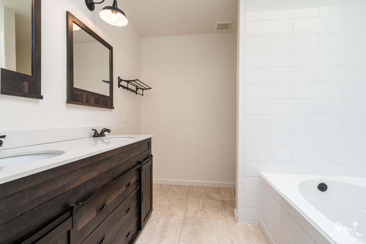 6987 Manhattan Drive Riverside, CA 92506 - Photo 14 of 28 a bathroom with a tub sink and mirror