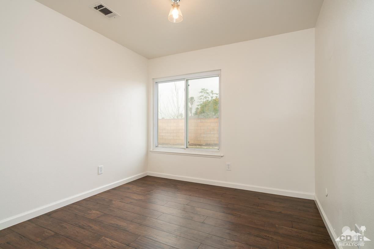 6987 Manhattan Drive Riverside, CA 92506 - Photo 16 of 28 an empty room with wooden floor and windows