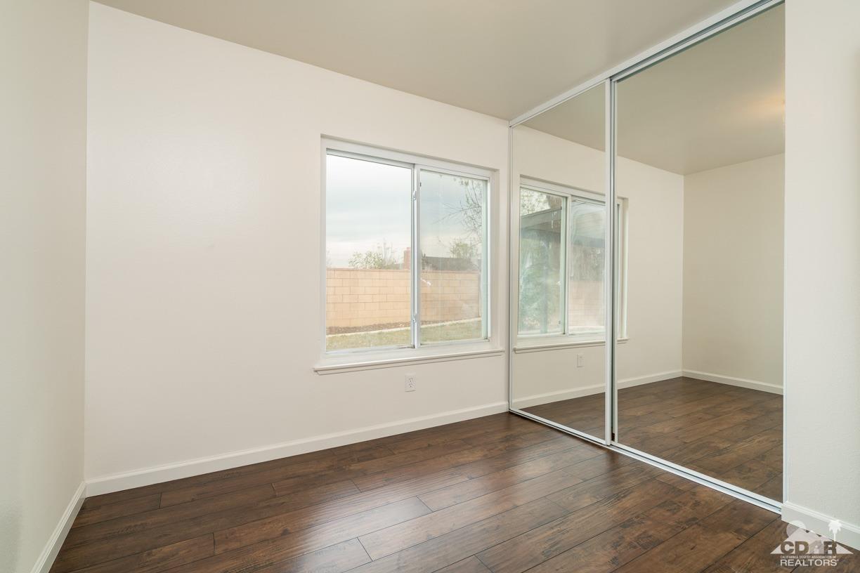 6987 Manhattan Drive Riverside, CA 92506 - Photo 17 of 28 an empty room with wooden floor and door