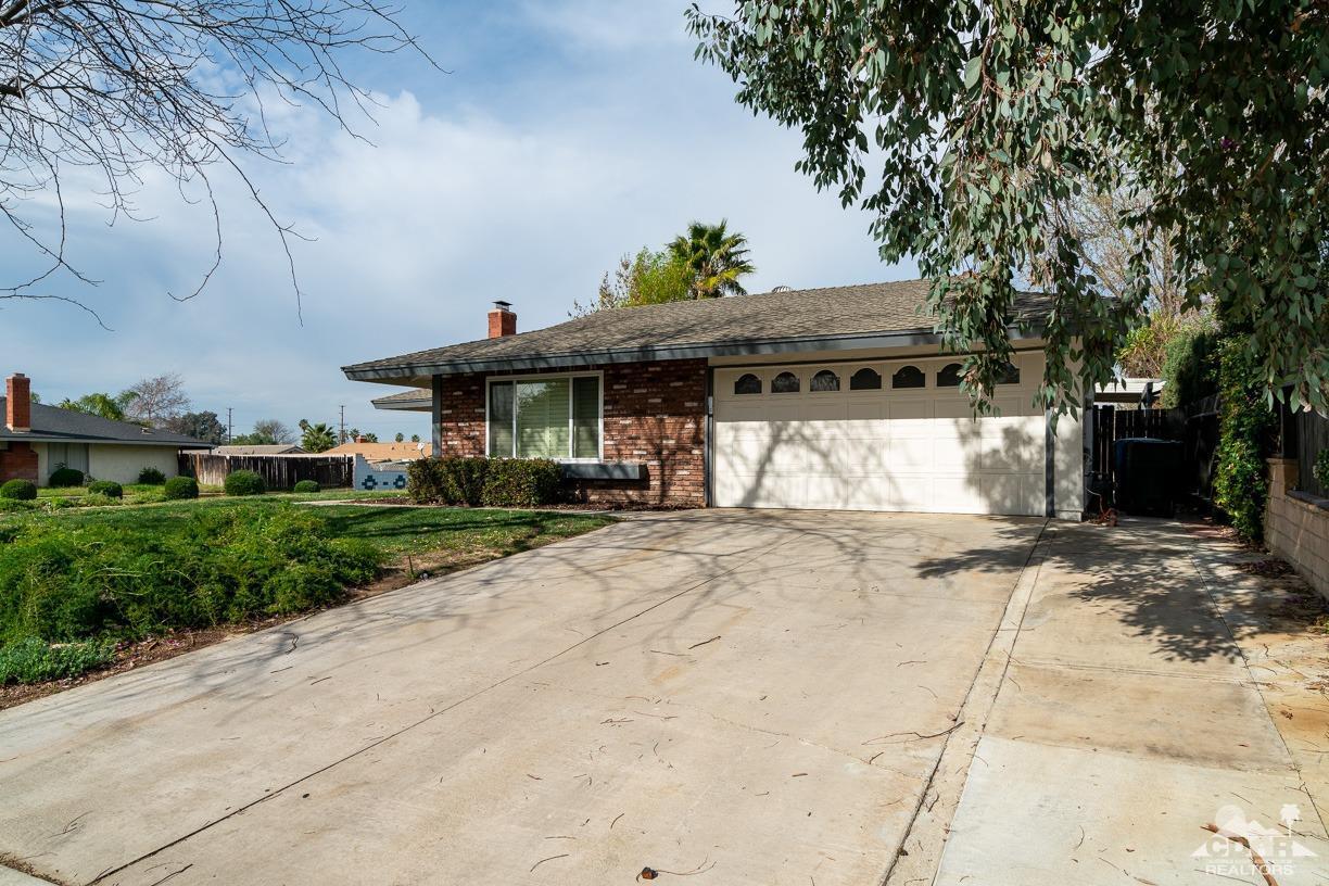 6987 Manhattan Drive Riverside, CA 92506 - Photo 22 of 28 a front view of a house with a yard and a garage