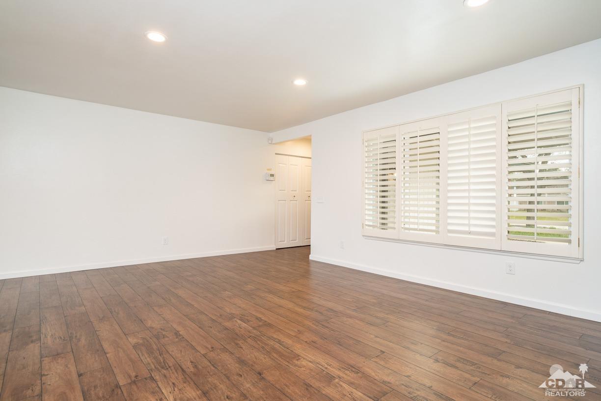 6987 Manhattan Drive Riverside, CA 92506 - Photo 9 of 28 a view of an empty room with wooden floor and a window