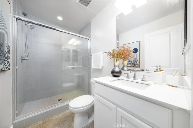 a bathroom with a granite countertop sink a toilet and a window