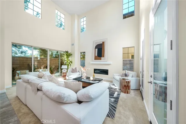 a living room with furniture fireplace and a large window